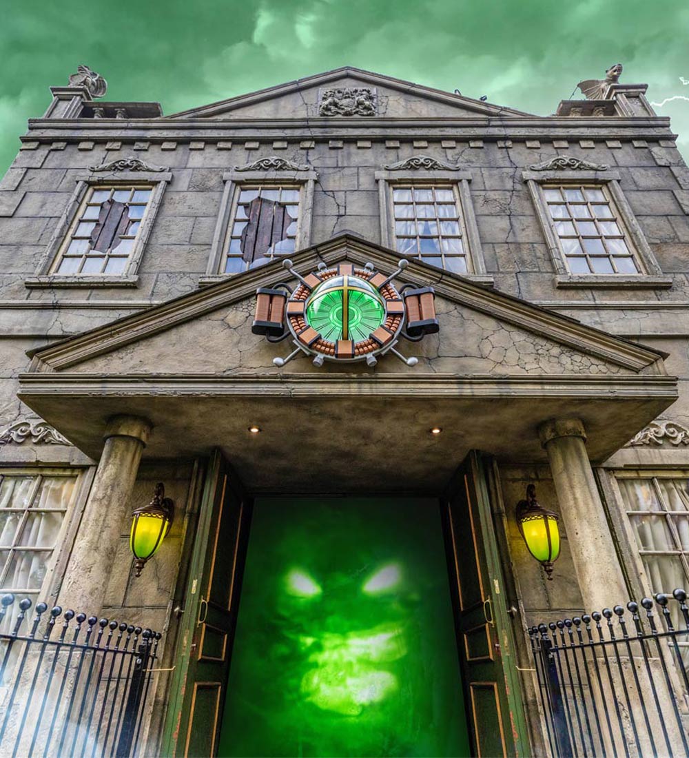 Entrance to Ghostly Manor dark ride with glowing green ghost at Paultons Park