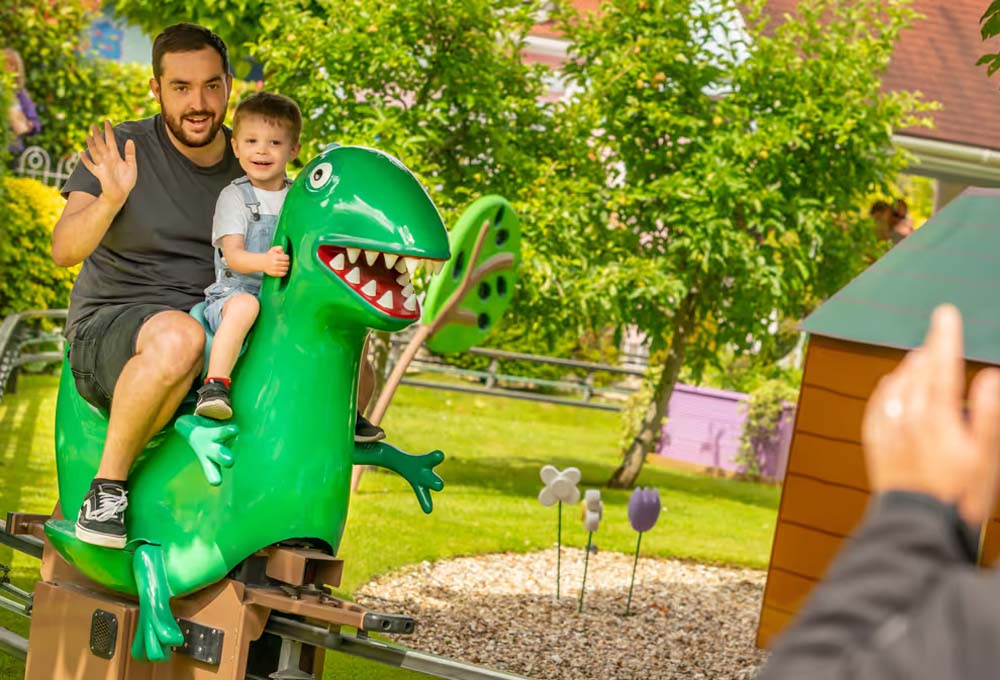 Father and child riding George’s Dinosaur Adventure in Peppa Pig World at Paultons Park