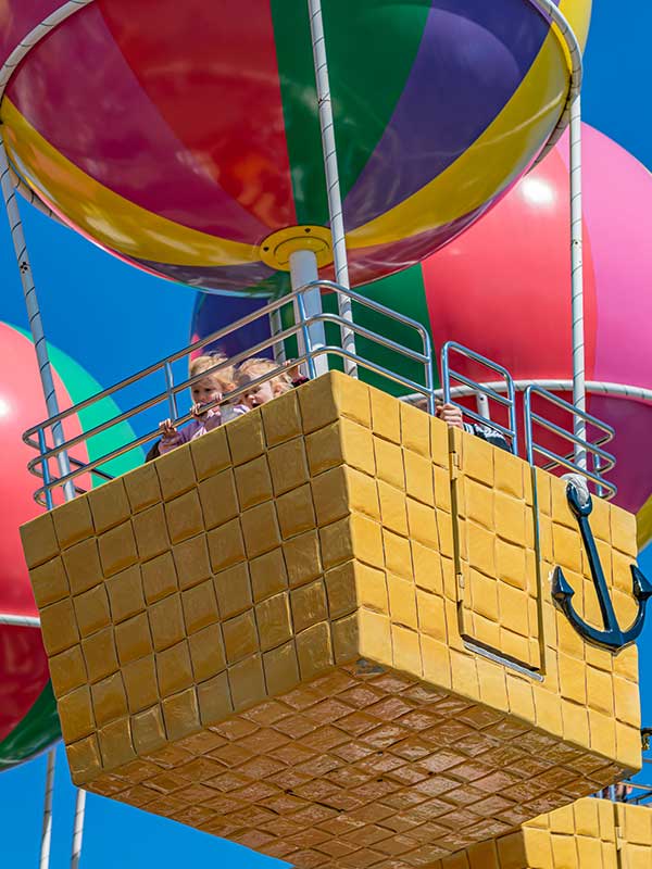 Family enjoying Peppa’s Big Balloon Ride in a colourful balloon basket at Peppa Pig World in Paultons Park