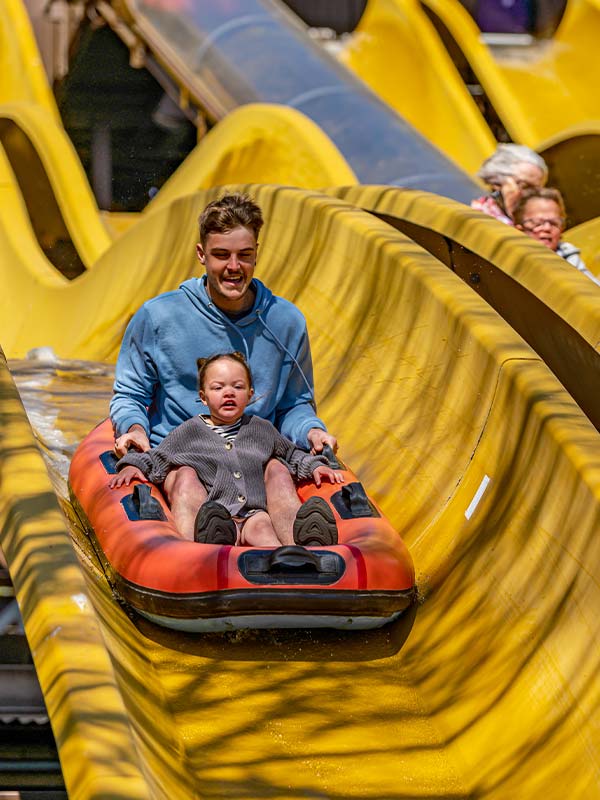 Father and daughter riding down the Buffalo Falls water slide at Paultons Park