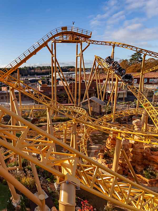 Storm Chaser spinning coaster racing past Route 83 Tornado Springs sign at Paultons Park