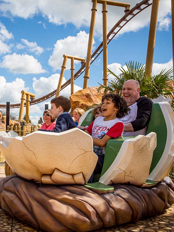 Guests laughing on Boulderdash spinning dinosaur egg ride at Paultons Park