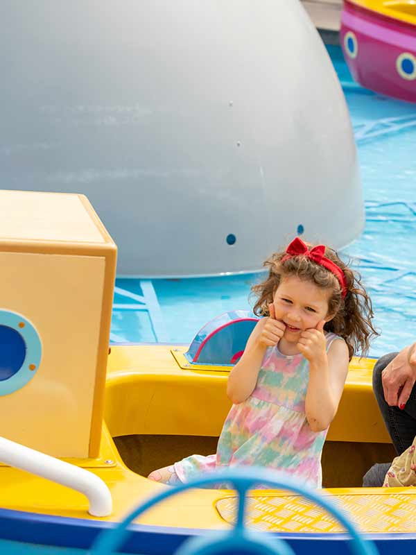 Mother and children giving thumbs up on Grandpa Pig’s Boat Trip in Peppa Pig World at Paultons Park