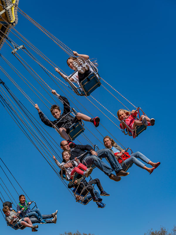 Family riding The Sky Swinger at Paultons Park with chairs suspended high in the air
