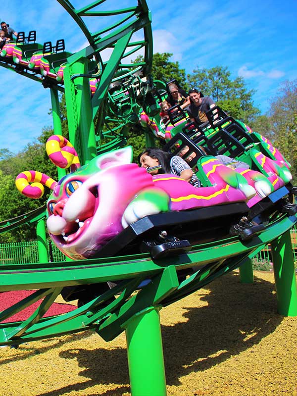 Families enjoying the Cat-O-Pillar Coaster at Paultons Park as the vibrant caterpillar train curves along the track