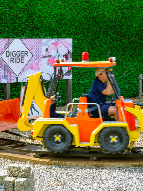 Young child steering a mini digger truck on the Digger Ride at Paultons Park