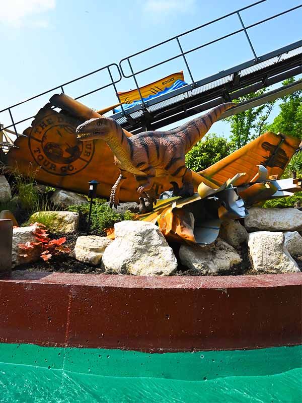 Dinosaur themed scenery beside Splash Lagoon water ride at Paultons Park