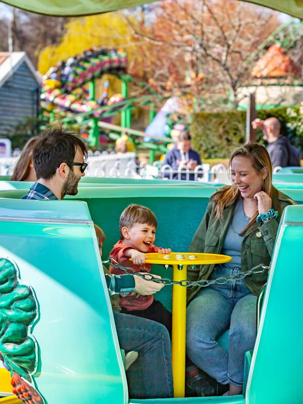 Parents and child laughing together on the Tea Cup Ride at Paultons Park