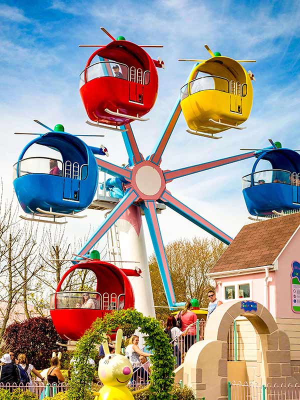 Close view of a red helicopter cabin on Miss Rabbit's Helicopter Flight at Peppa Pig World in Paultons Park with parent and child enjoying the ride