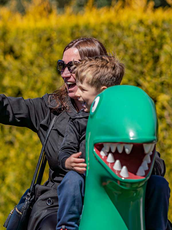 Mother and child laughing together on George’s Dinosaur Adventure ride in Peppa Pig World at Paultons Park