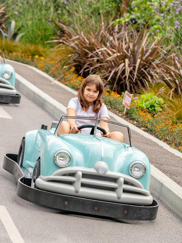 Child driving a turquoise car around the track at Al’s Auto Academy at Paultons Park
