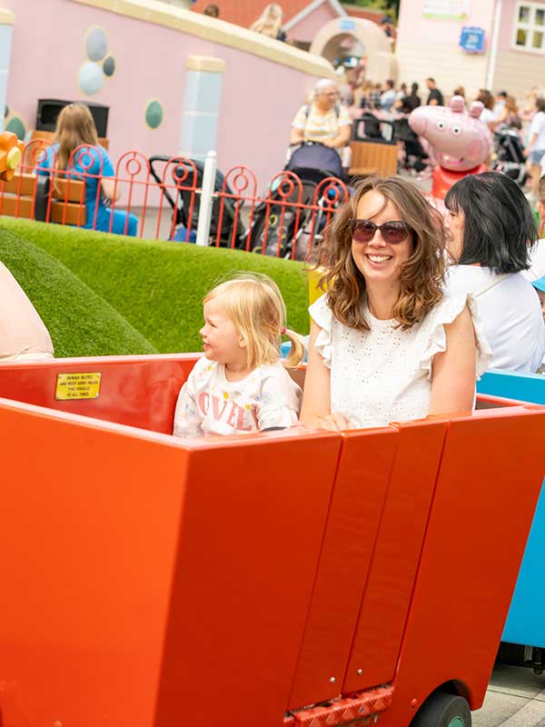 Mother and child smiling on Grandpa Pig’s Little Train Ride in Peppa Pig World at Paultons Park