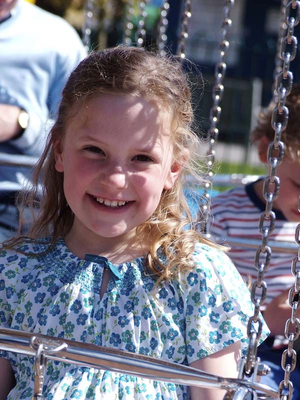 The Sky Swinger sign in front of the spinning swing ride at Paultons Park