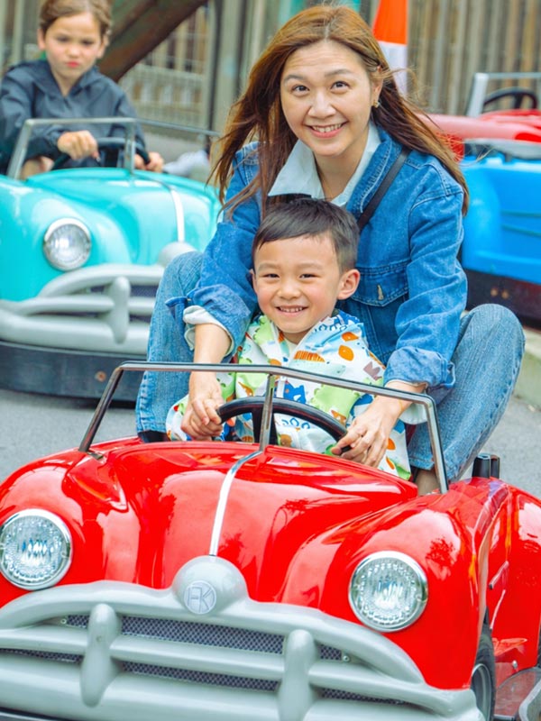 Mother and son smiling while driving a red car at Al’s Auto Academy at Paultons Park family car ride