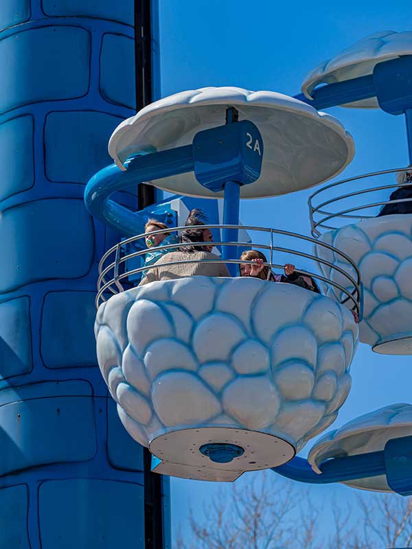 Family waving from Windy Castle Ride cloud gondola at Peppa Pig World in Paultons Park