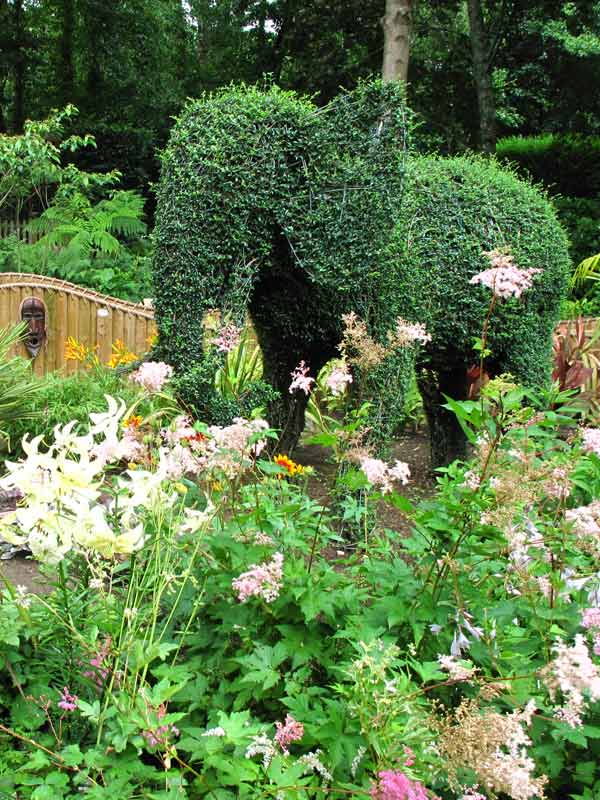 Stone waterfall cascading into a clear pond in Jungle Falls Garden at Paultons Park
