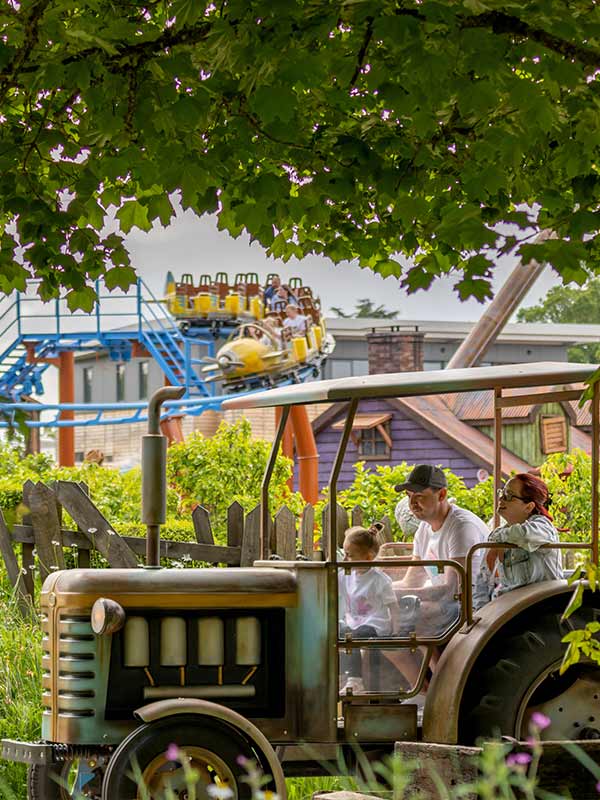 Family riding Trekking Tractors at Paultons Park driving through the themed farm area