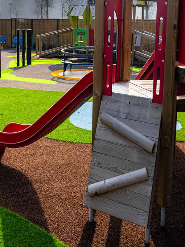 Wooden climbing frame and red slide in Parking Lot Tots Play Area at Paultons Park