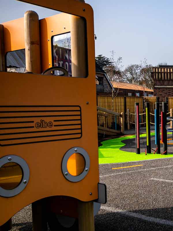 Yellow play bus structure in Parking Lot Tots Play Area at Paultons Park