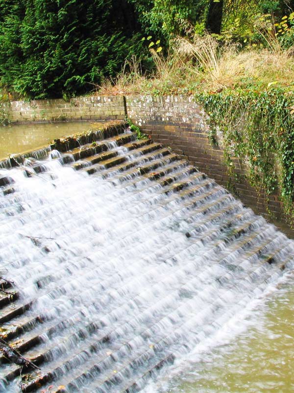 Water flowing over the stepped weir at Lake and Weir in Paultons Park