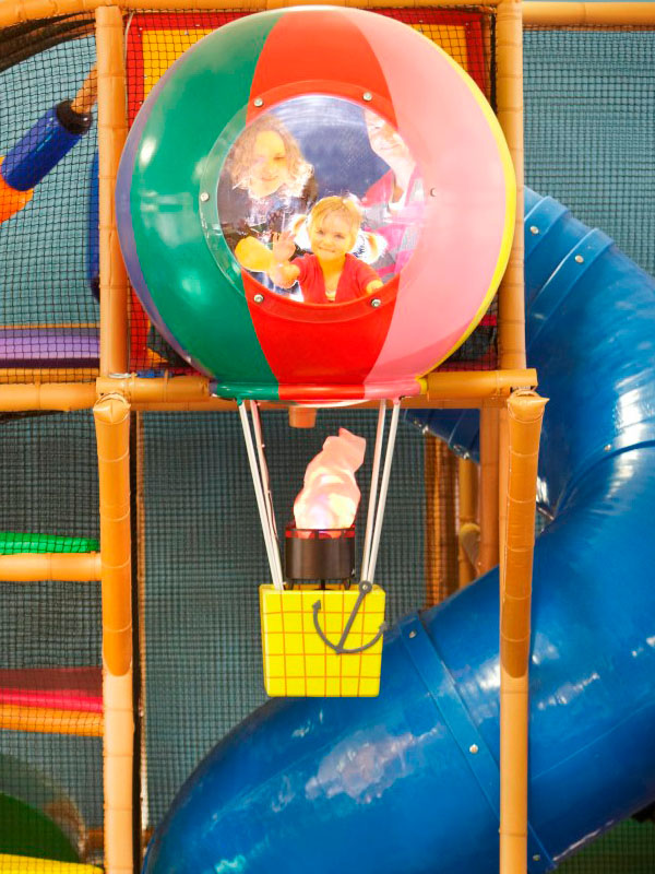 Children playing inside the colourful hot air balloon feature at George's Spaceship Indoor Playzone in Peppa Pig World at Paultons Park