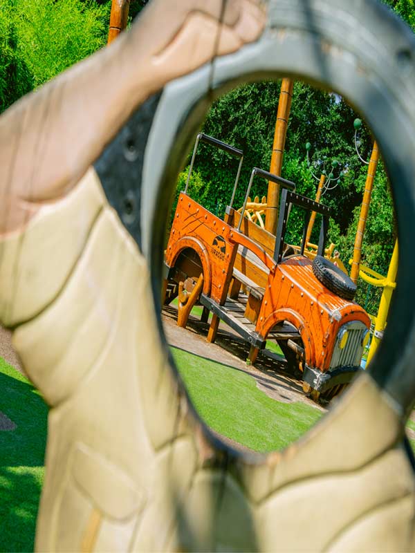 View of dinosaur themed jeep through carved dinosaur frame at Little Explorers Playground in Lost Kingdom at Paultons Park