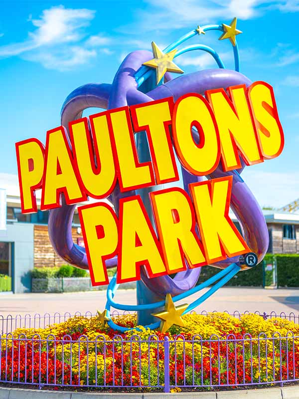 Paultons Park globe logo sculpture with yellow and red lettering in front of landscaped