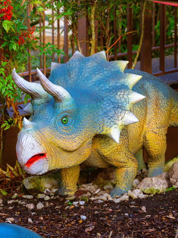 Triceratops dinosaur statue in landscaped garden at Pre-Historic Dinosaurs in Paultons Park