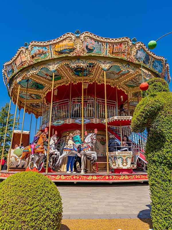 Family enjoying the Victorian Carousel Ride at Paultons Park with colourful carousel horses