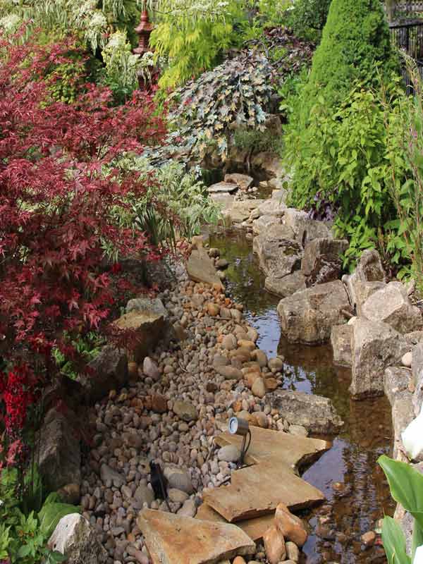 Rock stream with pebbles and colourful foliage in the Japanese Garden at Paultons Park
