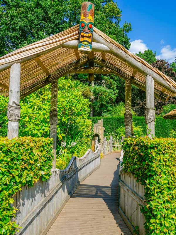 Picnic seating area in African Gardens at Paultons Park with wooden tables and thatched umbrellas