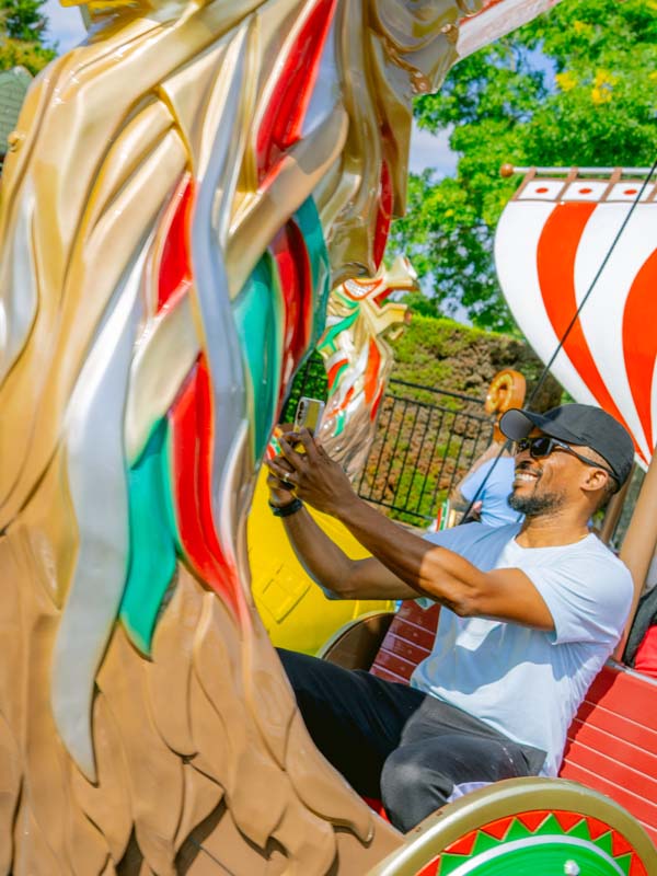 Guest smiling while riding Viking Boats with colourful dragon detail at Paultons Park