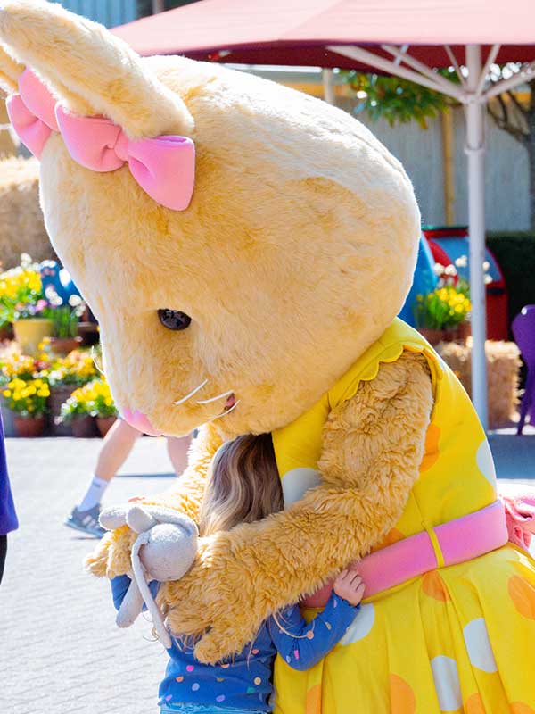 Easter Bunny mascot hugging a young child during Easter celebrations at Paultons Park