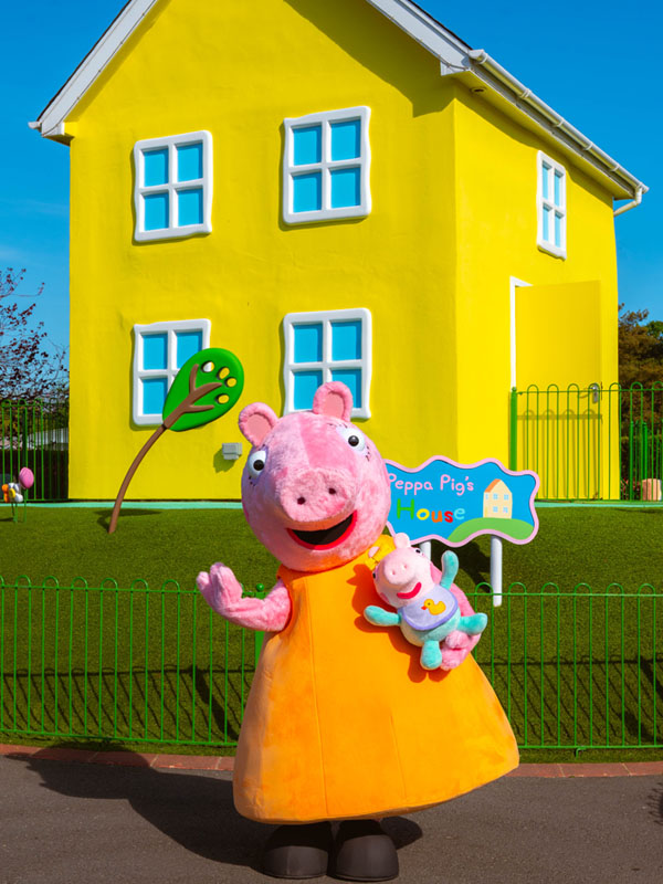 Peppa Pig waving outside Peppa’s House in Peppa Pig World at Paultons Park