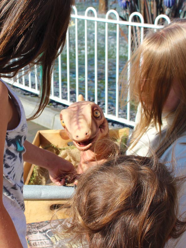 Children gathered around Chewie the baby dinosaur at Lost Kingdom in Paultons Park