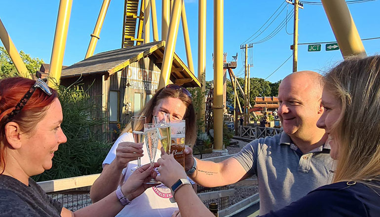 Guests raising drinks together during an exclusive evening event at Paultons Park