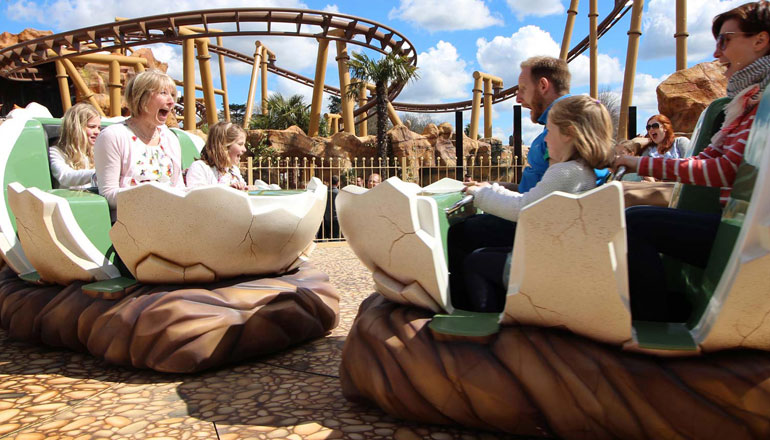 Families enjoying a dinosaur themed ride during a family fun day at Paultons Park