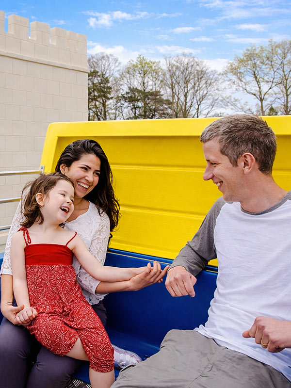 Family riding colourful royal carriage on The Queen’s Flying Coach Ride in Peppa Pig World at Paultons Park