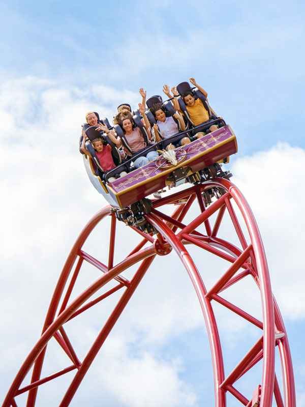 Family riding Drakon rollercoaster at Paultons Park with hands raised on the red track