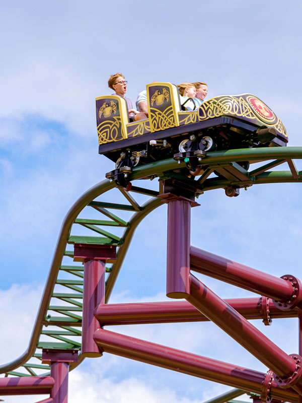 Family riding Raven Coaster in Valgard at Paultons Park, travelling along the twisting track.