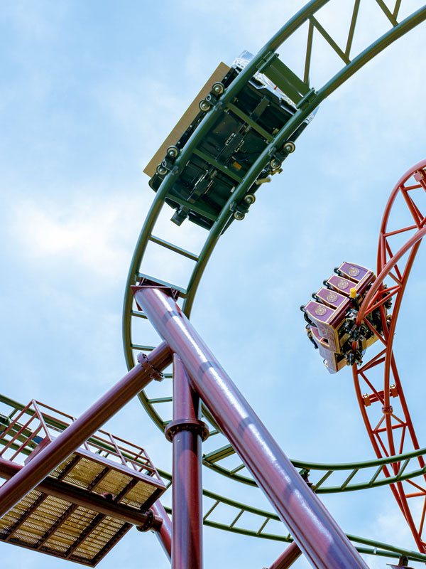 Raven Coaster train twisting through the green and red track in Valgard at Paultons Park.