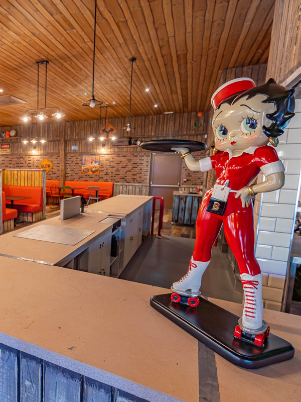 Betty Boop figure at the Route 83 counter in Tornado Springs at Paultons Park, with diner seating in the background.