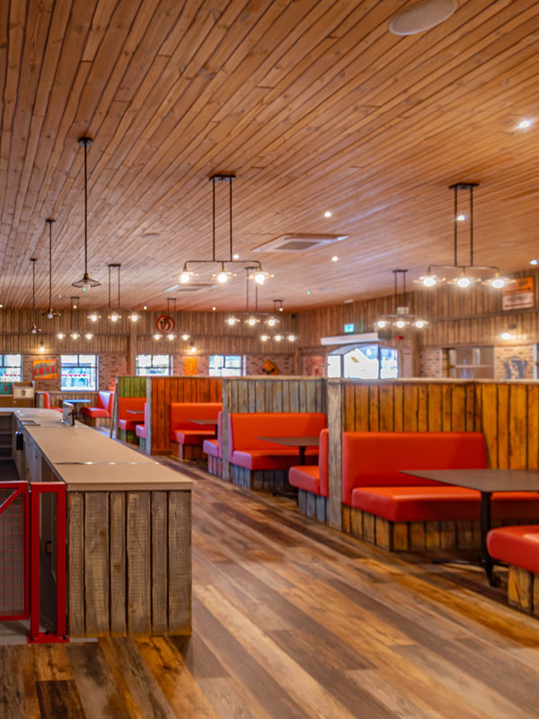 Route 83 diner interior in Tornado Springs at Paultons Park, with wooden booths, red seating and retro American styling.