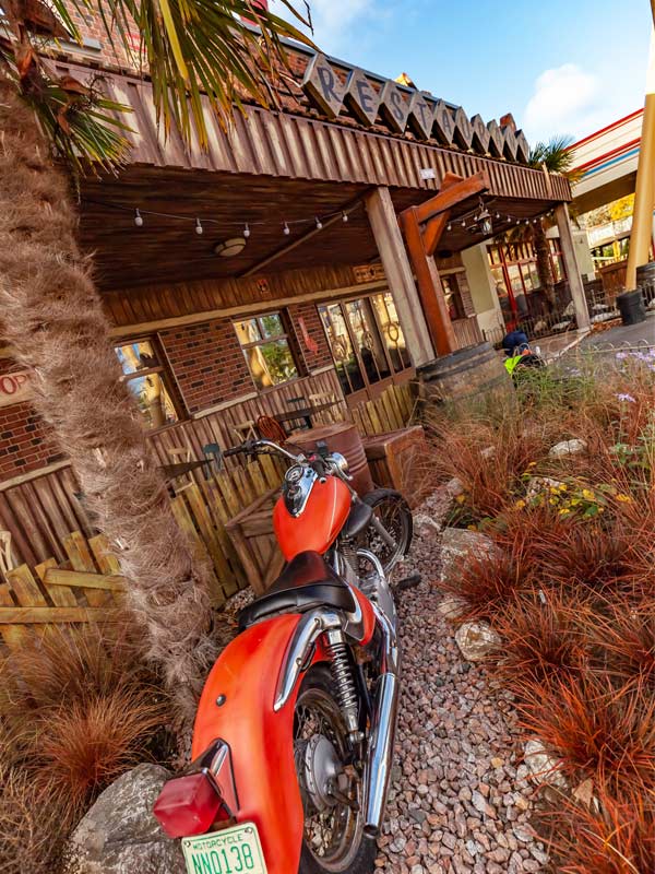 Exterior of Route 83 in Tornado Springs at Paultons Park, with a red motorbike and themed desert-style planting.