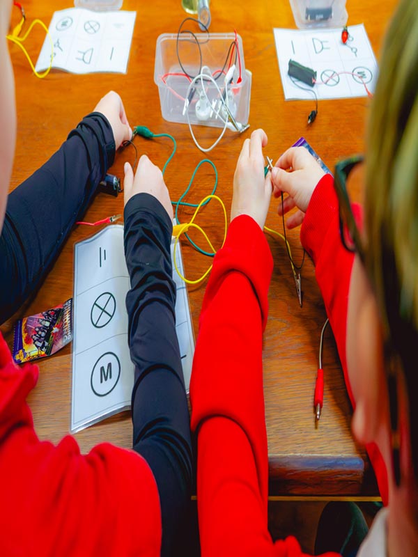 Children building electrical circuits with wires and components during a Super Circuits Workshop at Paultons Park.