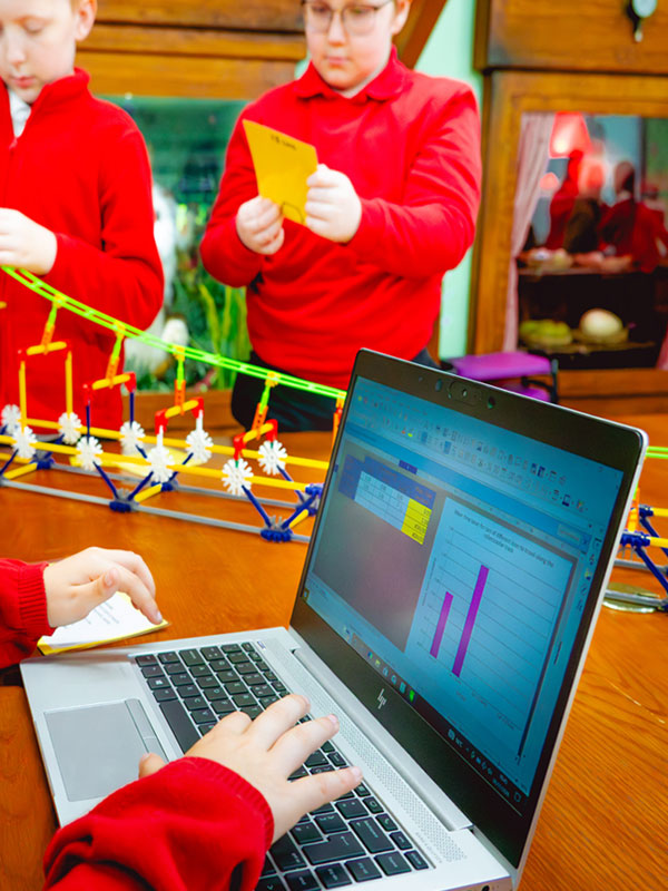 Children using a laptop to record results during the Air Resistance Challenge Workshop at Paultons Park.