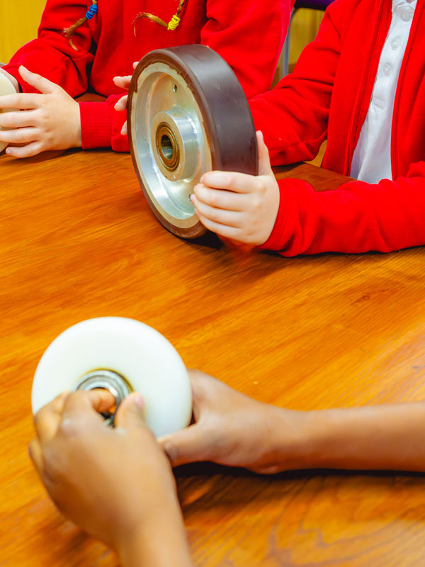 Children examining ride wheels during a Rollercoaster Forces workshop at Paultons Park.