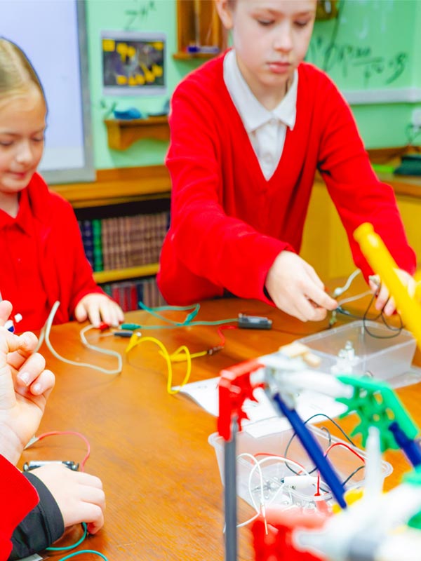 Children connecting wires and testing circuit components during a Super Circuits Workshop at Paultons Park.