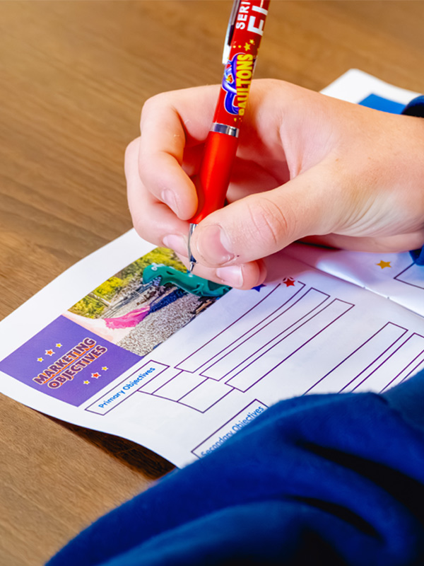 Paultons Park school trip workshop activity sheet showing a pupil completing a marketing objectives task