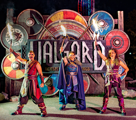 Valgard performers posing in front of the Realm of the Vikings sign during Halloween